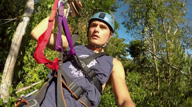 A selfie of a young man having fun zip lining through the jungle on a sunny day