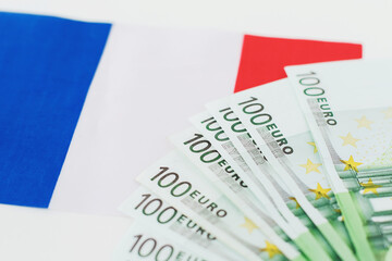 flag of france and several 100 euro banknotes on white background