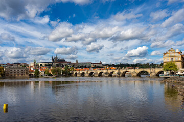 Fototapeta premium Prague, Czech Republic amazing panoramic view. World famous heritage Charles Bridge, medieval stone arch bridge that crosses the Vltava river. Bridge and embankment at autumn sunny day. 