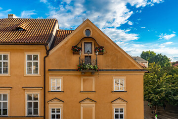Prague, Czech Republic amazing view at autumn sunny day. Beautiful yellow building with tile roof and balcony.  