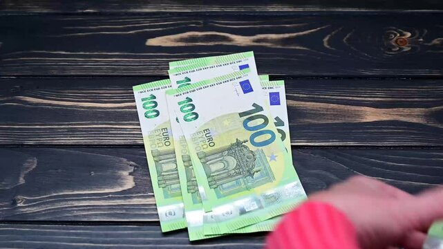 video of counting 100 Euro banknotes on dark wooden surface