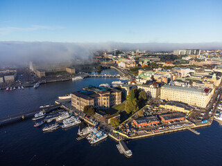 Fog rolling in over the royal palace and the old city of Stockholm, aerial view. Bright blue sky above