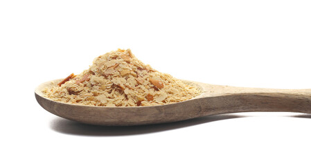 Nutritional yeast pile (deactivated yeast) in wooden spoon isolated on white, side view
