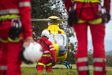 Rear view of team of emergency medical service. Doctor and paramedics with safety harness and...