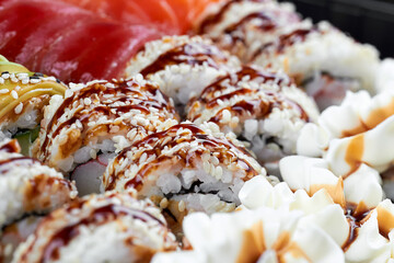 Sushi rolls with sesame, soy glaze, and whipped cream garnish