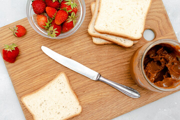 Sandwich toast bread with peanut butter, strawberry,nuts on cutting board. kids childrens baby's sweet dessert, healthy breakfast,lunch, food art on gray background,top view,flatlay