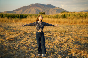 A Joyful Young Woman Happily Embracing Nature in a Beautiful and Scenic Landscape