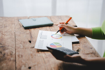 Accountant working at desk using laptop and calculator to calculate financial transactions, taxes, company income. Finance and tax concepts