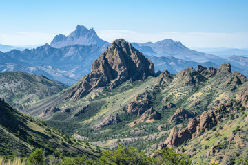 Fototapeta premium A rugged mountain range with sharp peaks and deep canyons, under a clear blue sky