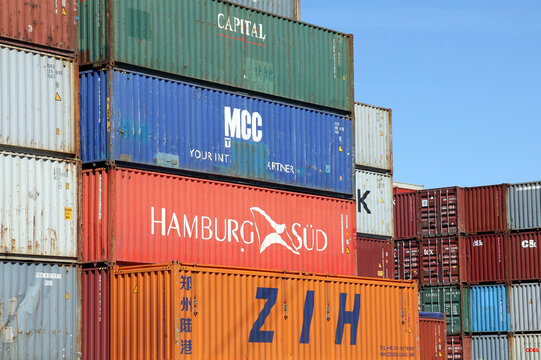 HAMBURG, GERMANY - JUNE 1, 2020: Stacked shipping containers of CAPITAL, MCC, HAMBURG S&Uuml;D and ZIH Zhengzhou International Hub at the Port of Hamburg and blue sky