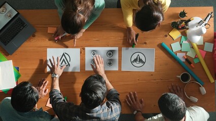 Top view of business team put graphic logo on meeting table with laptop and paper and start to...