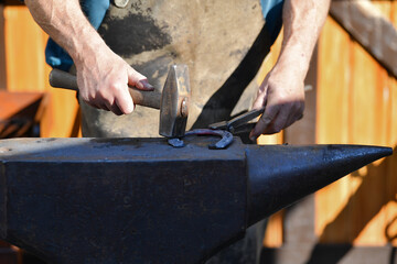 Blacksmith with a hammer working on a horseshoe