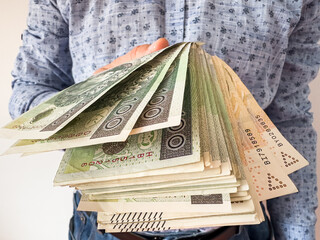Rich male holds and count 100 200 zloty pln zl banknotes. Polish currency