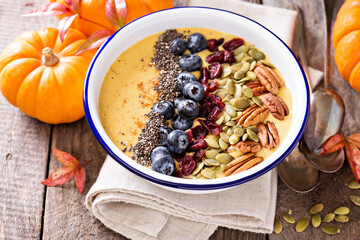 Pumpkin smoothie bowl with chia seeds, pecans, cranberries