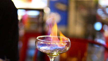 Making process of Burning cocktail absinthe by woman bartender in bar. Nightlife entertainment