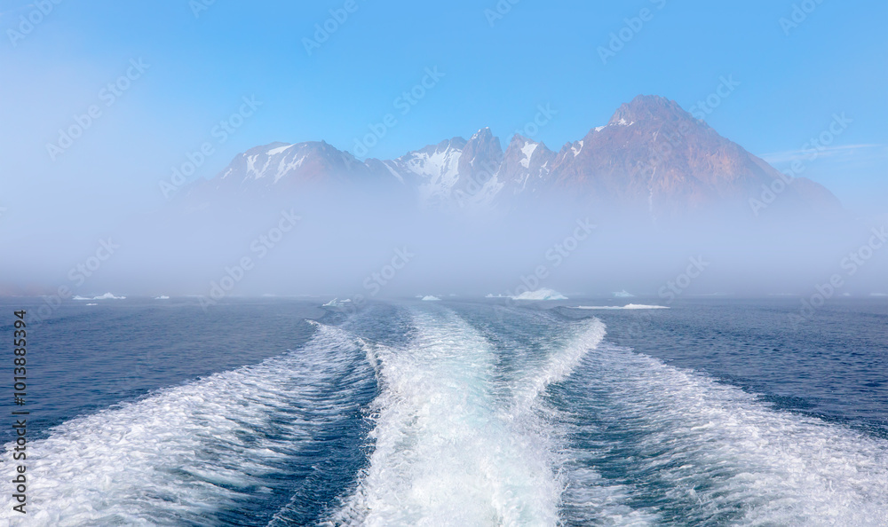 Poster fast moving motorboat trying to get out of the ice with rainbow in dense fog - stranded icebergs in 