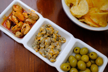 typical spanish aperitiv vermut before lunch with olives cockles mussels and chips