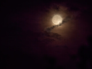 full moon under heavy clouds