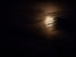 full moon under heavy clouds