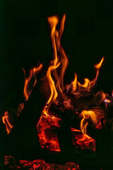 płomienie ognia w ognisku lub w kominku na ciemnym tle © Henryk Niestrój