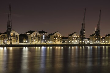 Renovated residential buildings and harbour cranes, Docklands, London, England, Great Britain