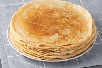 Stack of traditional russian pancakes blini on gray background. Homemade russian thin pancakes blini. Russian food, russian kitchen