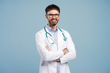 Fototapeta premium Attractive doctor with arms crossed wearing white coat and stethoscope isolated on blue background
