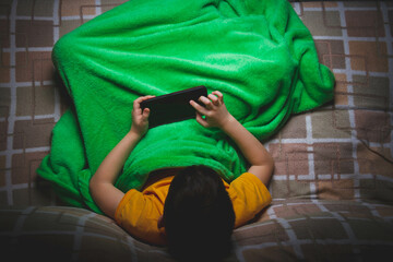 Phone in hands of child. Little boy playing mobile games on smartphone. Hand closeup.