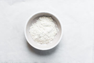 overhead view of All purpose flour in a bowl, top view of baking flour in a ceramic bowl