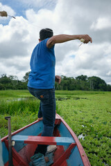 Adult fishing on traditional wooden canoe , Amazon natural reserve