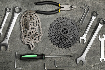 Parts of bicycle and tools on grey table, flat lay