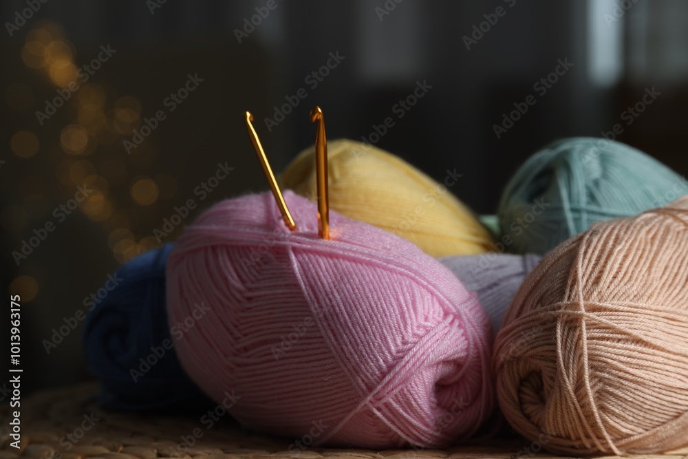 Wall mural Knitting material. Skeins of soft yarn and crochet hooks on wicker surface indoors, closeup