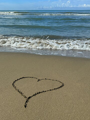 Heart on the sand beach of sea shore.