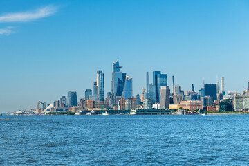 Fototapeta premium Panoramic view of the Manhattan skyline from Hoboken, New Jersey, set against a clear blue sky. 