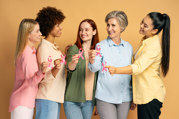 Five women smiling and showing pink ribbons for breast cancer awareness