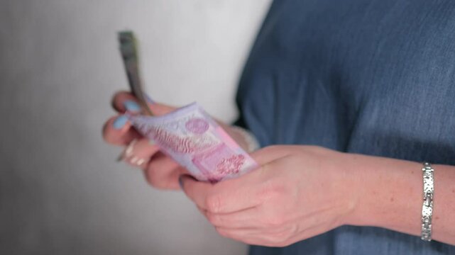 Female hands holding paper bills Belarusian rubles