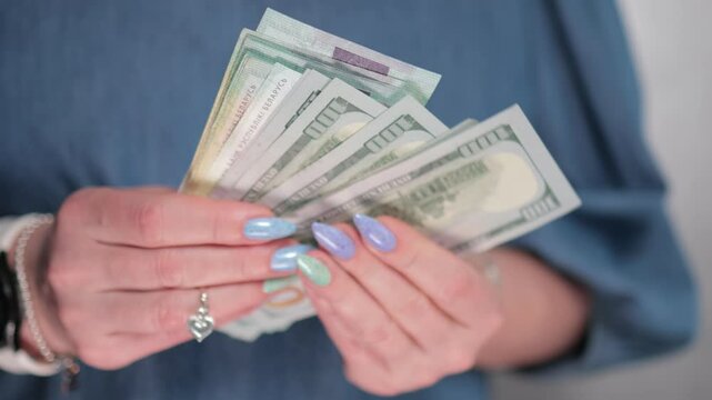 Female hands holding paper bills of US dollars and Belarusian rubles