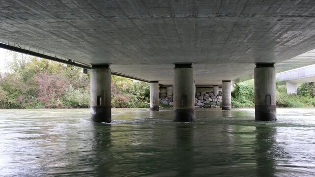 Beton Br&uuml;ckenkonstruktion &uuml;ber einen Fluss, Tragende Br&uuml;cken Beton Pfeiler in einem str&ouml;mendem Fluss, Fluss Wasser unter einer Br&uuml;cke, Br&uuml;ckenbau , Video Aufnahme unter einer Beton Autobahn Br&uuml;cke