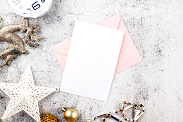 White empty paper card mockup space in envelope with Christmas gifts boxes and baubles. Xmas invitation, flyer or greeting card mock up.