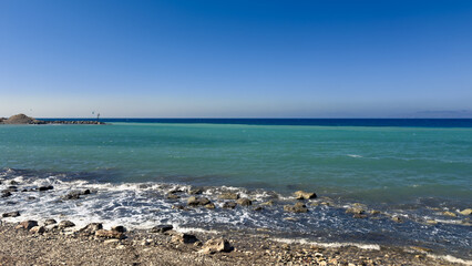 Tranquil Seascape at a Coastal Location During a Clear Day With Gentle Waves Lapping Against a Rocky Shore