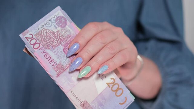 Female hands holding paper bills Belarusian rubles