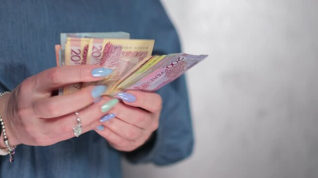 Female hands holding paper bills Belarusian rubles