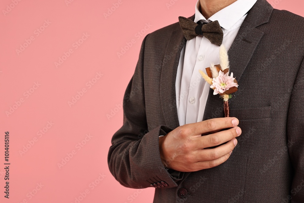 Canvas Prints Groom in suit with stylish boutonniere on pink background, closeup. Space for text