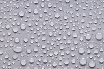 Water drops on gray background, top view