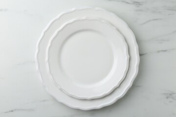 Stylish plates on white marble table, top view