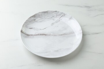 Stylish plate on white marble table, closeup