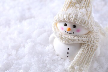 Cute decorative snowman on artificial snow, closeup. Space for text