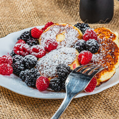 Cottage cheese pancakes with fresh raspberries, blackberries and powdered sugar