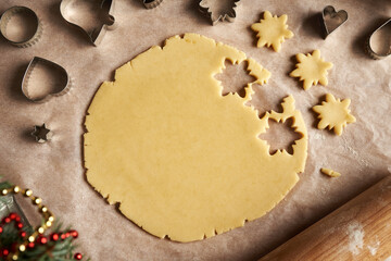 Cutting out shapes from rolled out dough to prepare traditional Linzer Christmas cookies, top view