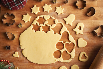 Cutting out shapes from rolled out dough to prepare traditional Linzer Christmas cookies, top view